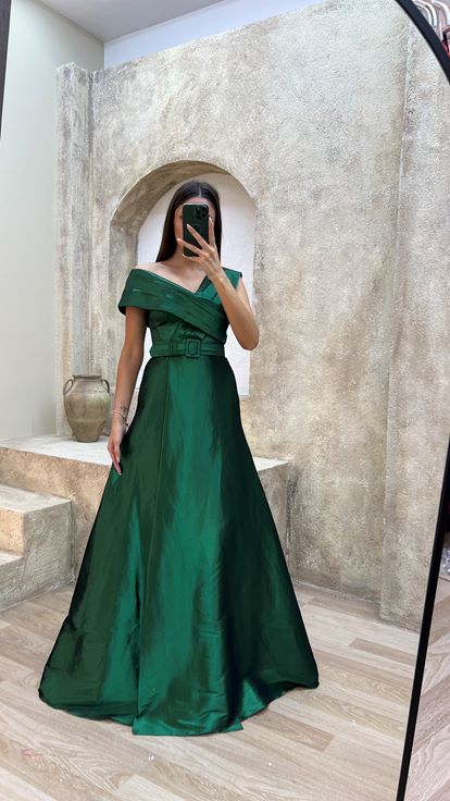 فستان سهرة من الساتان الزمردي بتفاصيل متقاطعة على الصدر والحزام