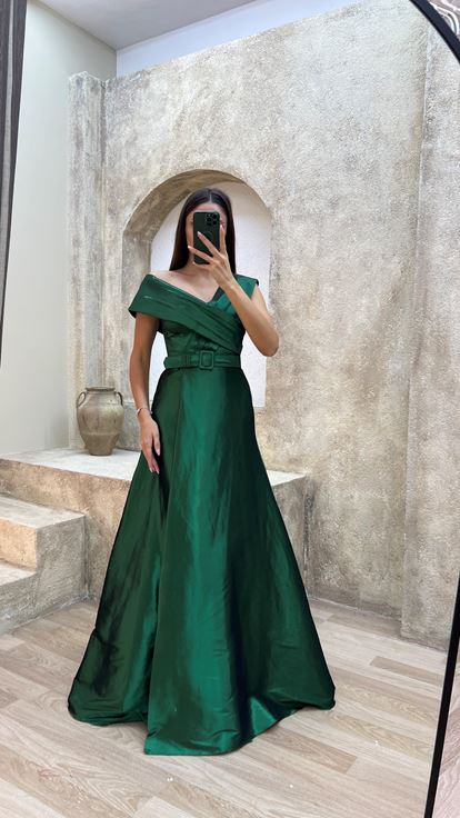 فستان سهرة من الساتان الزمردي بتفاصيل متقاطعة على الصدر والحزام