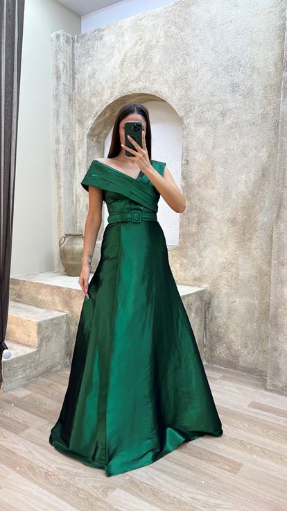 فستان سهرة من الساتان الزمردي بتفاصيل متقاطعة على الصدر والحزام
