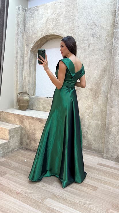 فستان سهرة من الساتان الزمردي بتفاصيل متقاطعة على الصدر والحزام