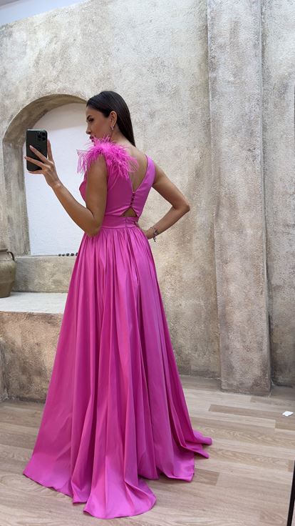 فستان سهرة وردي اللون بتفاصيل عند الخصر وريش