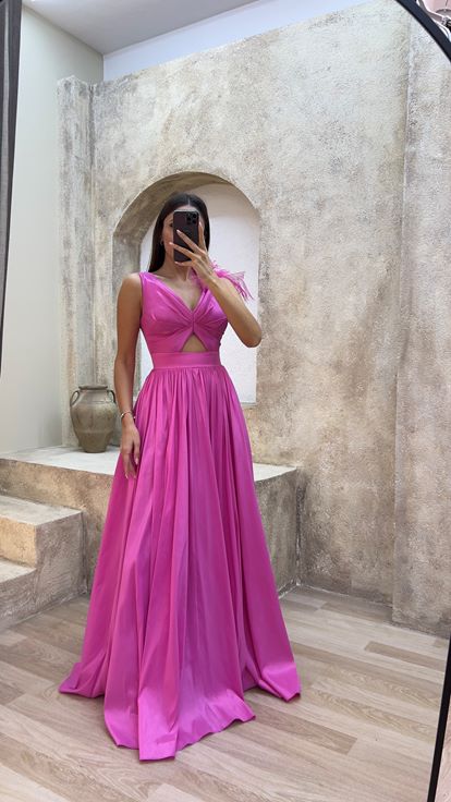 فستان سهرة وردي اللون بتفاصيل عند الخصر وريش