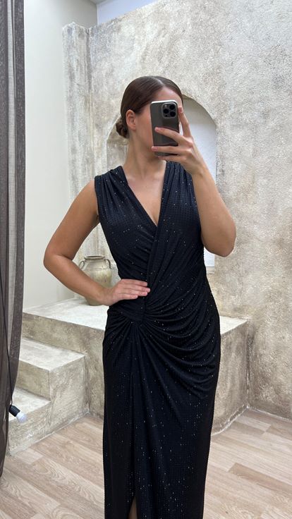 فستان سهرة أسود بمقاسات كبيرة، بياقة على شكل حرف V وتفاصيل عند الخصر