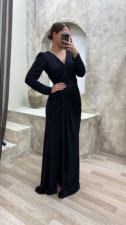 فستان سهرة أسود بمقاسات كبيرة، بياقة على شكل حرف V وتفاصيل عند الخصر