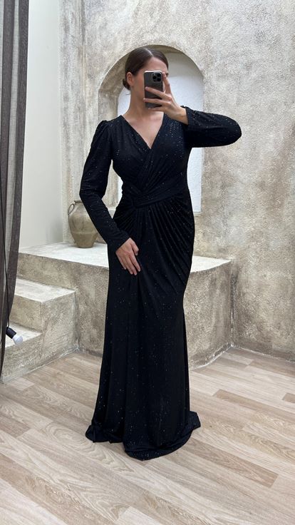 فستان سهرة أسود بمقاسات كبيرة، بياقة على شكل حرف V وتفاصيل عند الخصر