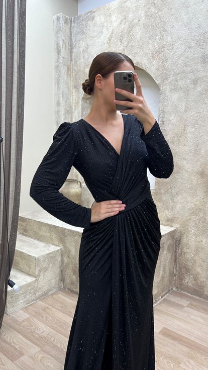 فستان سهرة أسود بمقاسات كبيرة، بياقة على شكل حرف V وتفاصيل عند الخصر