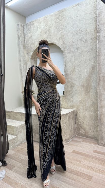 فستان سهرة أسود مطرز بتصميم خاص، بكتف واحد وأكمام واسعة 