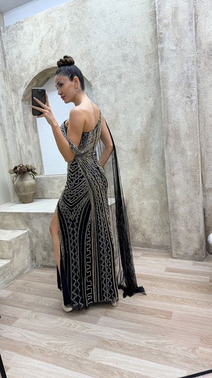 فستان سهرة أسود مطرز بتصميم خاص، بكتف واحد وأكمام واسعة 