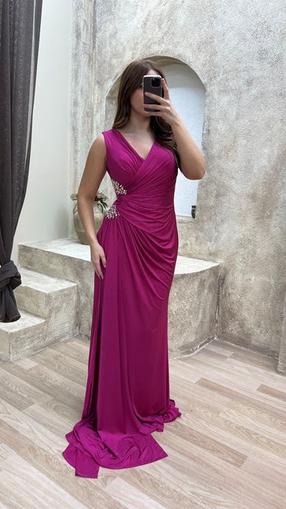 فستان سهرة وردي اللون بمقاسات كبيرة وفتحة رقبة على شكل حرف V، مزين بأحجار عند الخصر