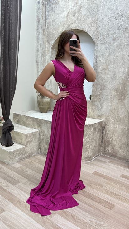 فستان سهرة وردي اللون بمقاسات كبيرة وفتحة رقبة على شكل حرف V، مزين بأحجار عند الخصر