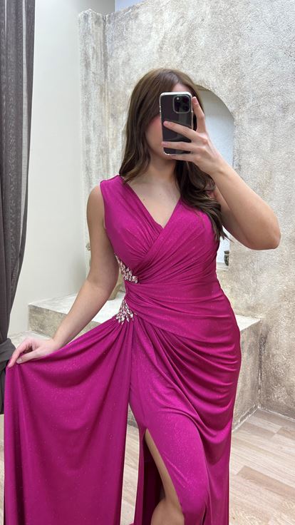 فستان سهرة وردي اللون بمقاسات كبيرة وفتحة رقبة على شكل حرف V، مزين بأحجار عند الخصر