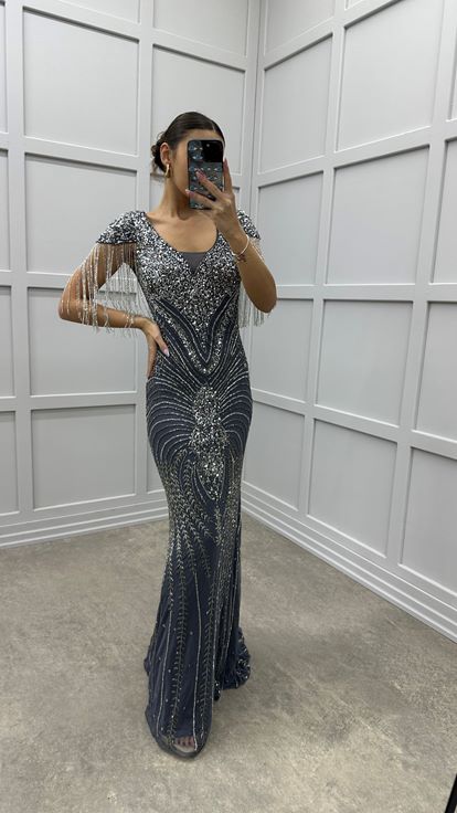 فستان سهرة رمادي بياقة على شكل حرف V مزين بشرابة على الكتفين وتصميم تطريز مميز