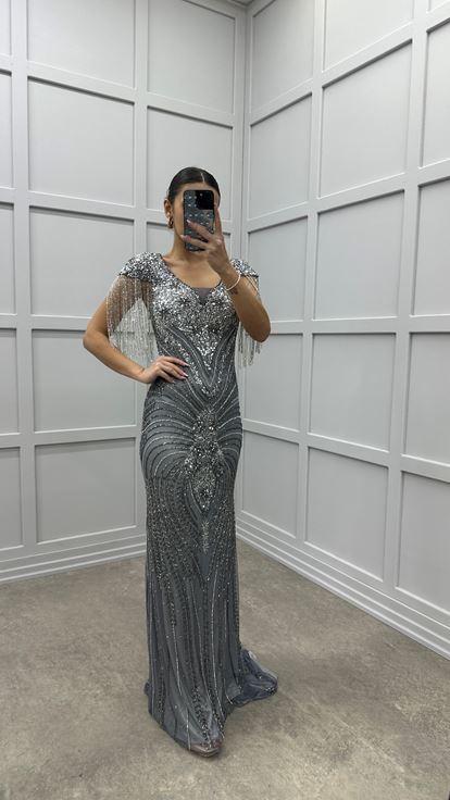 Robe de soirée grise avec détail au niveau de la poitrine  manches à pompons et broderie spéciale 