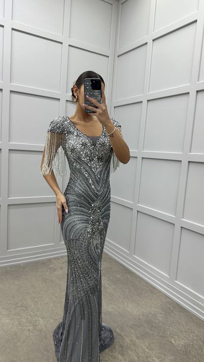 Robe de soirée grise avec détail au niveau de la poitrine  manches à pompons et broderie spéciale 