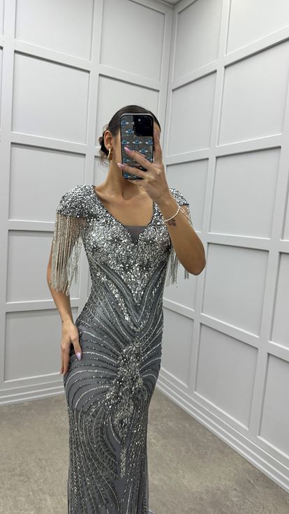 Robe de soirée grise avec détail au niveau de la poitrine  manches à pompons et broderie spéciale 