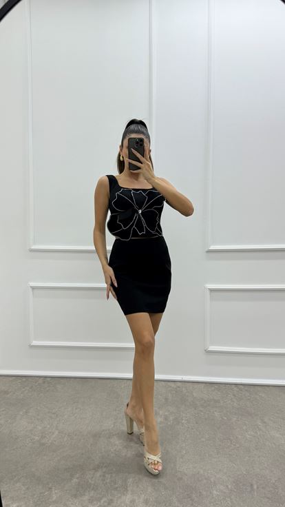 Conjunto de dos piezas tipo bustier negro con detalles florales y pedrería 