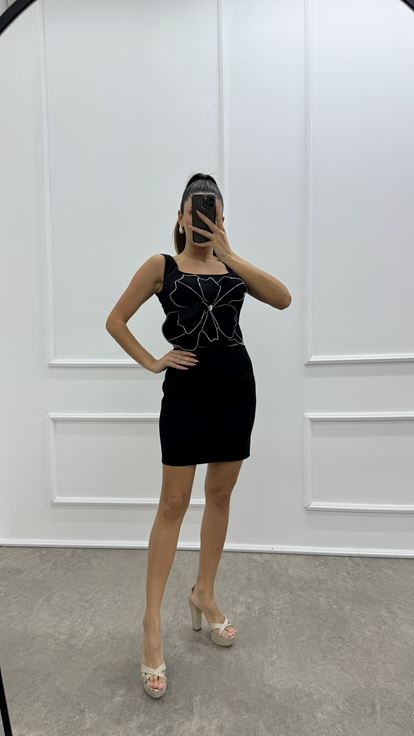 Conjunto de dos piezas tipo bustier negro con detalles florales y pedrería 