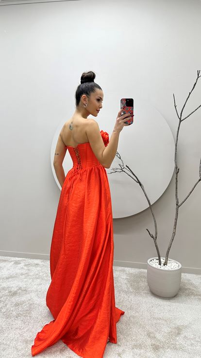 Vestido de noche naranja con detalle floral en el busto 