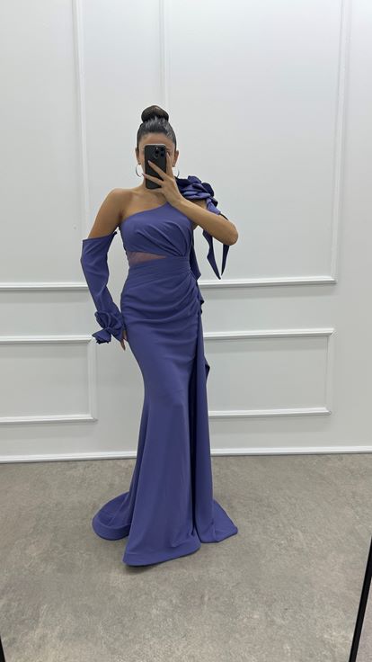 فستان سهرة مصمم بتفاصيل كشكشة على الكتف بلون أرجواني فاتح مزين بوردة وردية