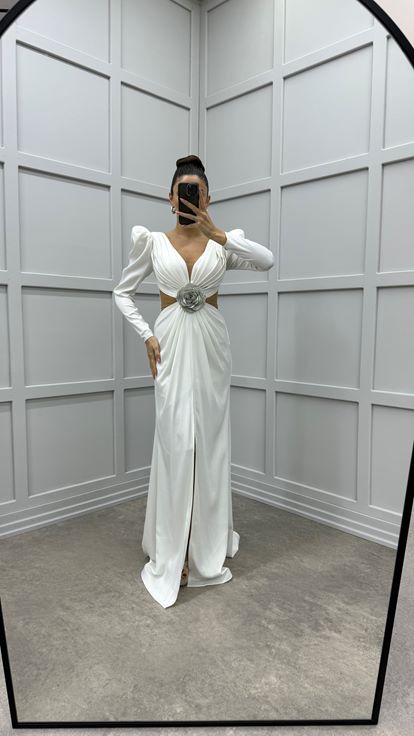 فستان أبيض من الساتان بتصميم مطوي عند الصدر وتفاصيل شفافة عند الخصر 