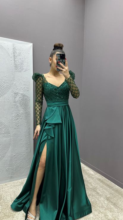 فستان سهرة من الساتان باللون الأخضر الزمردي مزين بأحجار على الصدر والخصر 