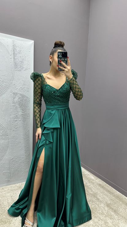 فستان سهرة من الساتان باللون الأخضر الزمردي مزين بأحجار على الصدر والخصر 