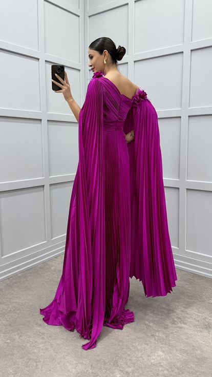 Vestido fucsia asimétrico con capa plisada y detalle de plumas