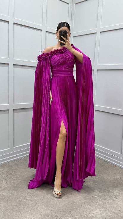 Vestido fucsia asimétrico con capa plisada y detalle de plumas
