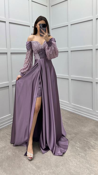 فستان سهرة من الساتان بلون وردي فاتح، بأكمام واسعة على الصدر وتفاصيل ترتر على الكتفين