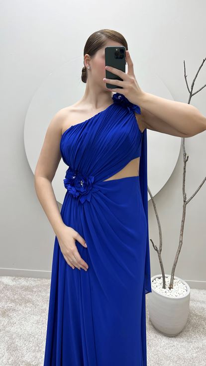 فستان سهرة من ساكس بمقاسات كبيرة بكتف واحد وتفاصيل وردة عند الخصر والكتف