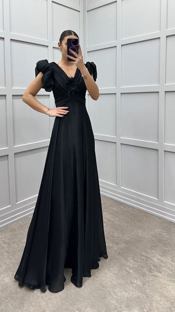 Schwarzes Abendkleid mit Blumendetail auf der Brust