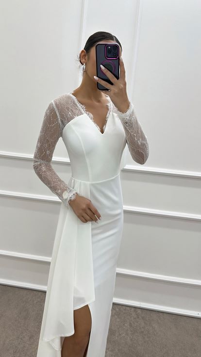 فستان أبيض بتصميم دانتيل وفتحة رقبة على شكل حرف V
