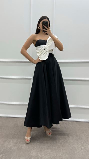 Vestido negro con lazo en el pecho de un hombro