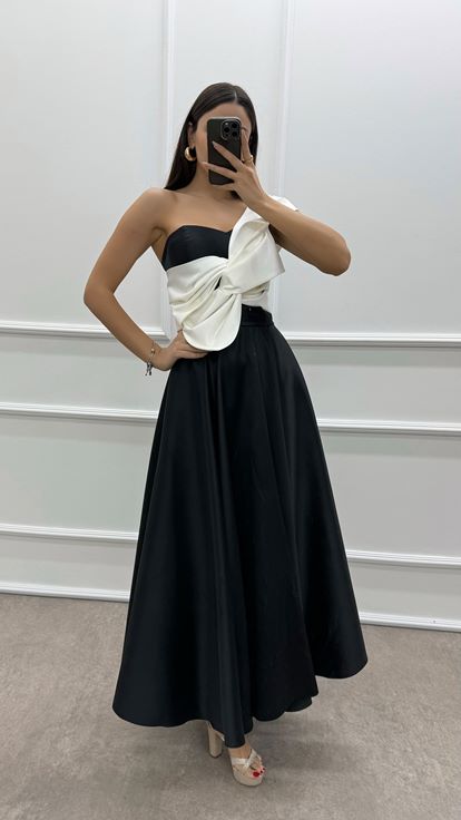 فستان أسود بكتف واحد مزين بفيونكة عند الصدر