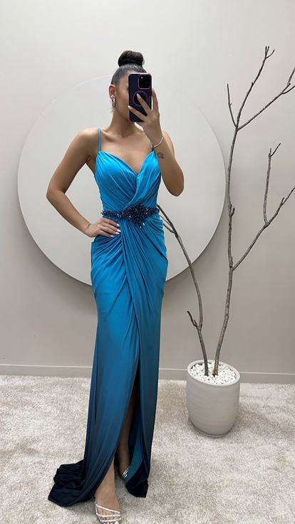 فستان سهرة بلون الفيروز بحمالات رفيعة وخصر مزين بتطريزات