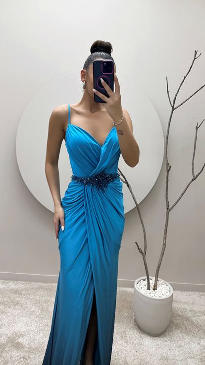 فستان سهرة بلون الفيروز بحمالات رفيعة وخصر مزين بتطريزات