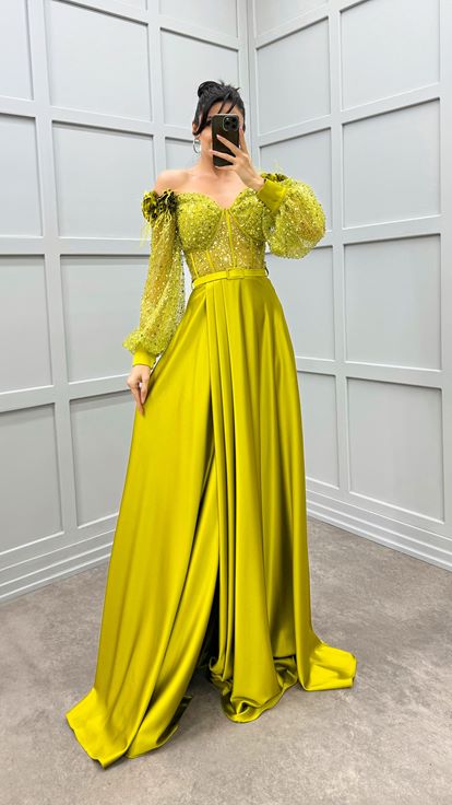 فستان أخضر بكتفين مزين بتفاصيل وردة وفستان سهرة من الساتان الشفاف المزين بالريش