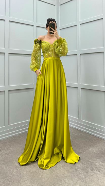 فستان أخضر بكتفين مزين بتفاصيل وردة وفستان سهرة من الساتان الشفاف المزين بالريش