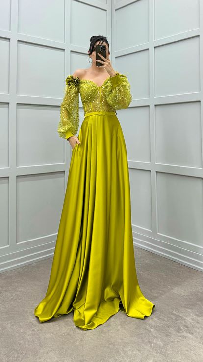 فستان أخضر بكتفين مزين بتفاصيل وردة وفستان سهرة من الساتان الشفاف المزين بالريش