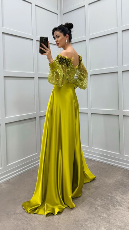 فستان أخضر بكتفين مزين بتفاصيل وردة وفستان سهرة من الساتان الشفاف المزين بالريش
