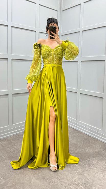 فستان أخضر بكتفين مزين بتفاصيل وردة وفستان سهرة من الساتان الشفاف المزين بالريش