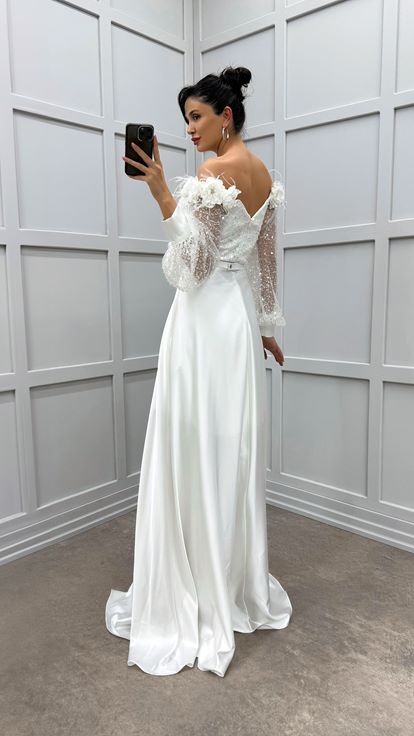 فستان أبيض مكشوف الكتفين مزين بتفاصيل من الورود والريش، فستان سهرة من الساتان الشفاف