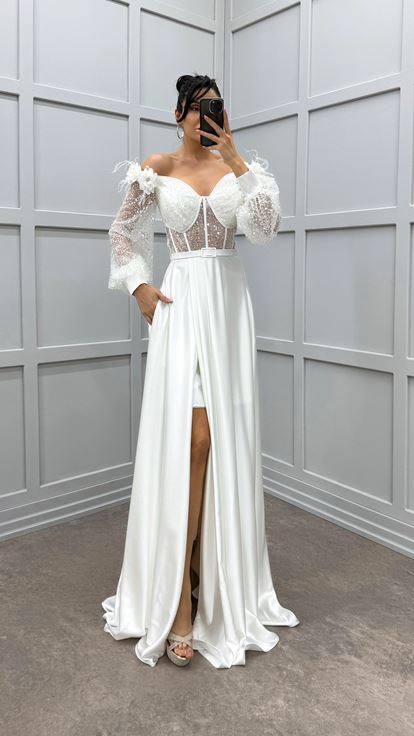فستان أبيض مكشوف الكتفين مزين بتفاصيل من الورود والريش، فستان سهرة من الساتان الشفاف