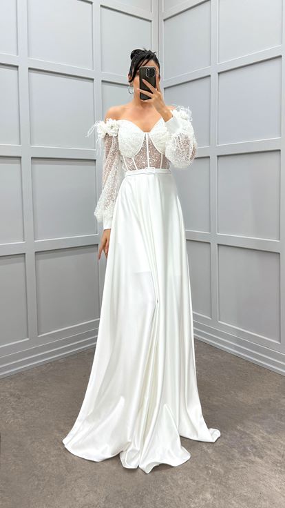 فستان أبيض مكشوف الكتفين مزين بتفاصيل من الورود والريش، فستان سهرة من الساتان الشفاف