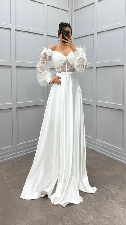 فستان أبيض مكشوف الكتفين مزين بتفاصيل من الورود والريش، فستان سهرة من الساتان الشفاف