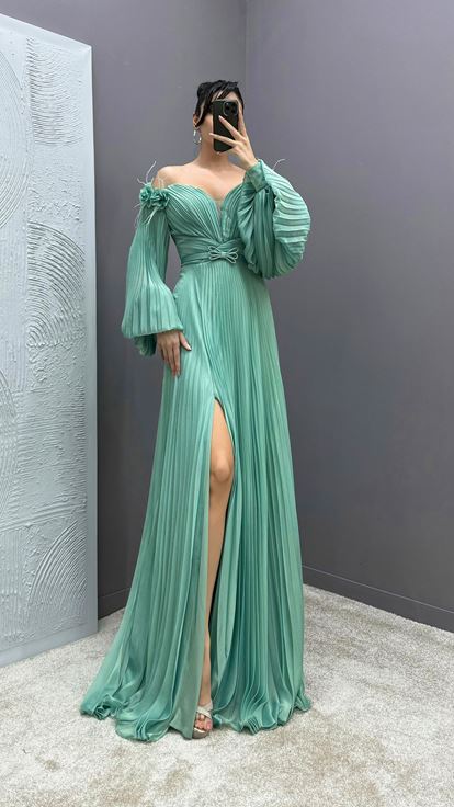 Mintgrünes Kleid mit Federapplikationen an den Schultern  Ballonärmeln und Faltenwurf 