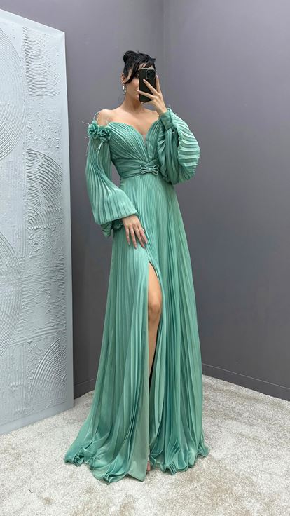 Mintgrünes Kleid mit Federapplikationen an den Schultern  Ballonärmeln und Faltenwurf 