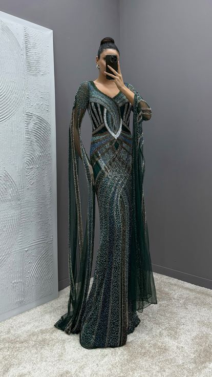 فستان سهرة مطرز بتصميم خاص شفاف بأكمام خضراء زمردية