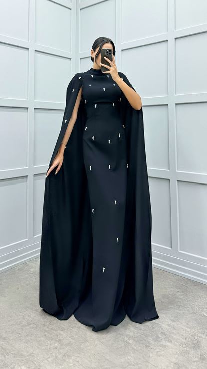 فستان أسود مزين بتفاصيل مرصعة بالأحجار على الأكمام