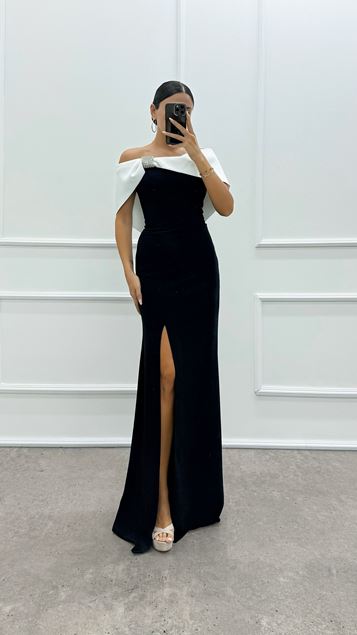 Vestido negro con diseño de abertura y broche en el pecho